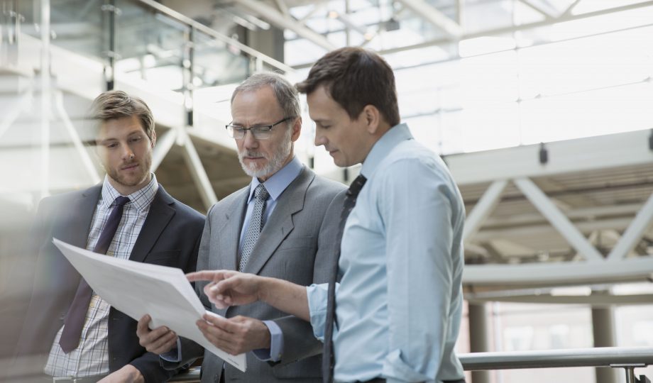 Businessmen discussing paperwork in meeting