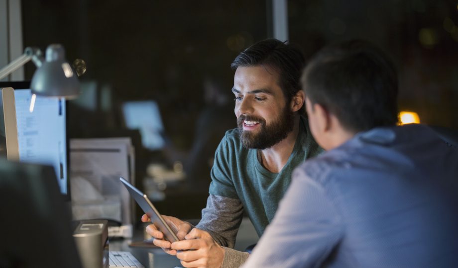Businessmen with digital tablet working late in office